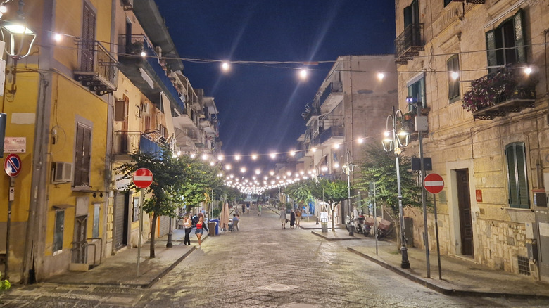 A downtown street in Bacoli lit up at night