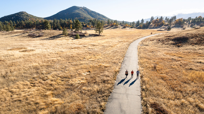 Three people hiking the prairie landscape of Cuyamaca Rancho State Park