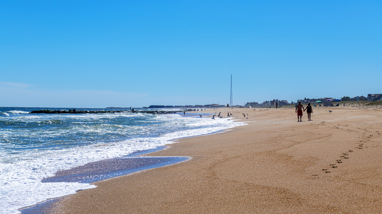 couple walks along the beach in Sea Girt, New Jersey