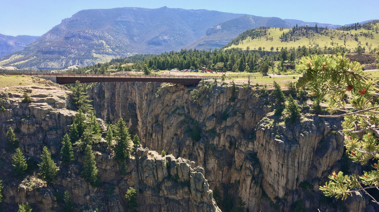 Sunlight Creek Bridge over plunging cliffsides against the mountain landscape of Sunlight Basin Wyoming