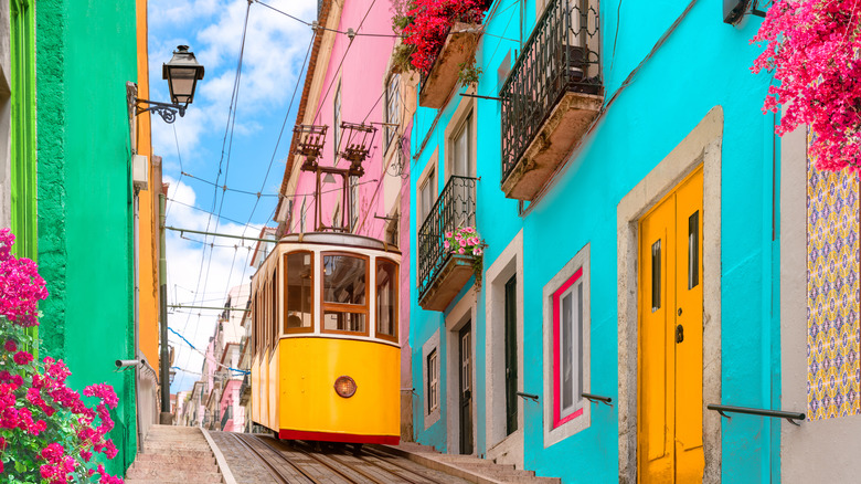 Image of the yellow tram of Elevador da Bica and colorful buildings in Rua da Bica
