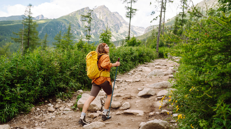 A woman hiking on the mountains with lush views all around