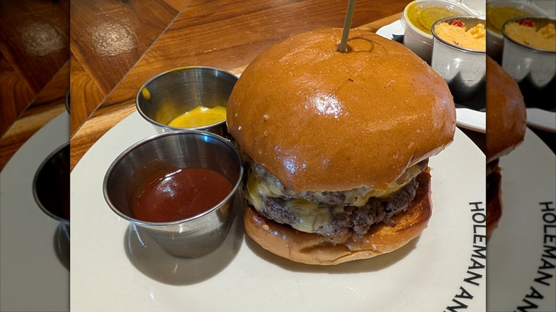 The signature H&F burger with a side of ketchup and mustard in Atlanta