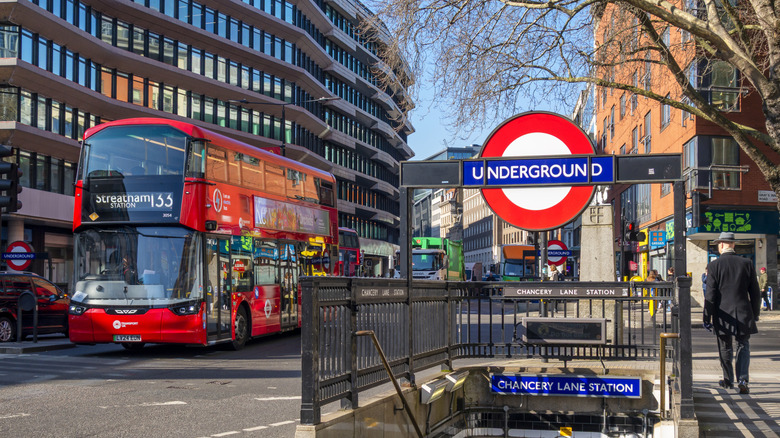 The streets of London, England, with a red double-decker bus and stairway leading to a London Underground station