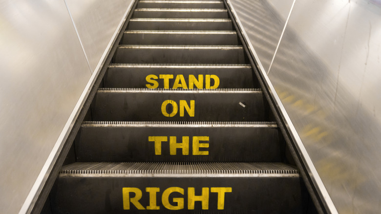 A sign stating "stand on the right" on a set of escalator stairs in the London Underground