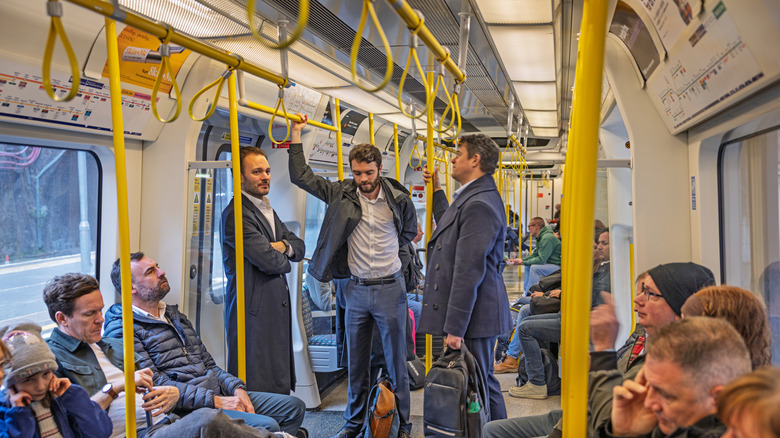 A group of people standing in the London Underground train, blocking the doors