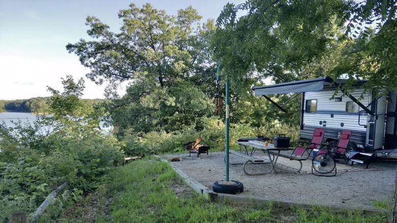 An RV parked behind a picnic table overlooking Lake Shelbyville