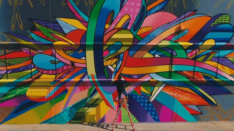 Street artist painting a mural in East Village Arts District, Long Beach, California