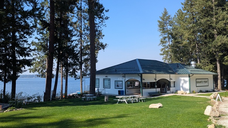 A waterfront lodge with picnic tables and trees at Granite Point Resort, Loon Lake, Washington