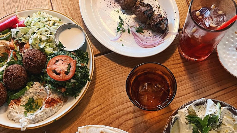 A variety of plates of Lebanese food on a wooden table
