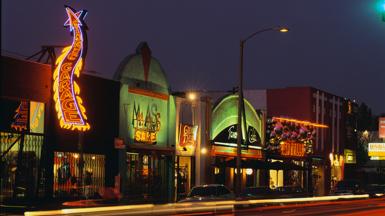 Neon signs glow on Melrose Ave at night in West Hollywood