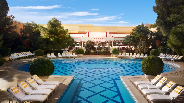 View of the Sunset Pool & Cabana Bar at Wynn Hotel in Las Vegas with sun beds surrounding an empty pool