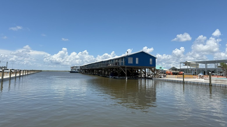 A house on stilts hovers above the water in Cocodrie, Louisiana
