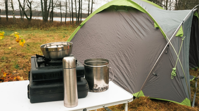 a lakeside camp setup with lake views and trees in sight