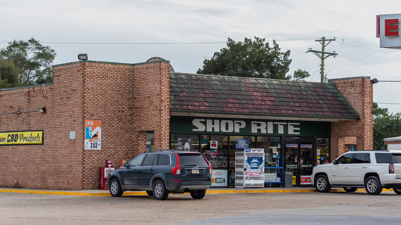 Two cars parked in front of a gas station and shop on Highway 90, near Broussard