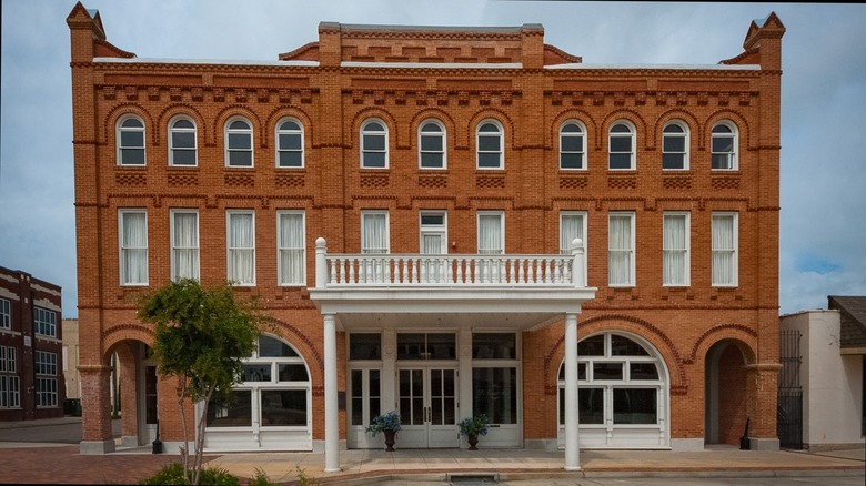 Red brick white trim building against cloudy sky Grand Opera House of the South