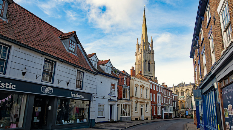 The spire of St. James' Church surrounded by buildings in the street in Louth, England