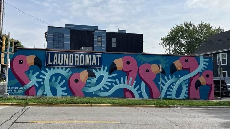 Mural of flamingoes with a sign that says laundromat