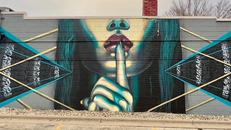 Mural of woman holding finger to her lips in Madison Wisconsin