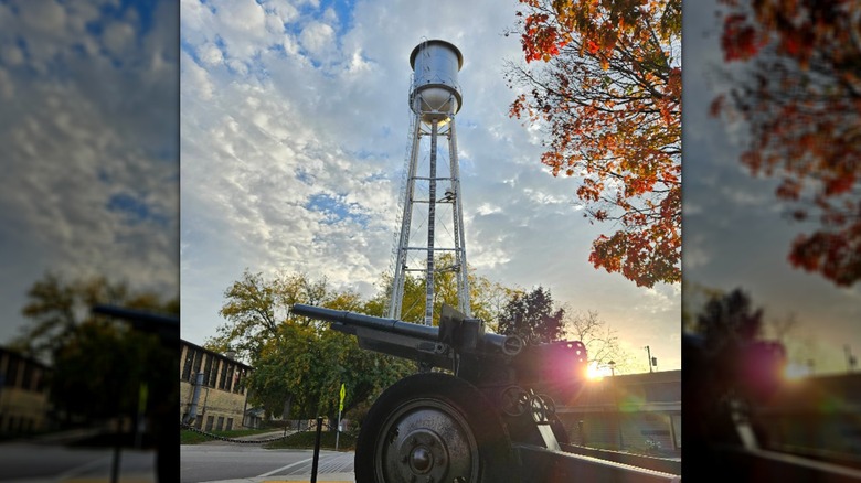 A historic artillery cannon in front of the Oregon Water Tower in Wisconsin