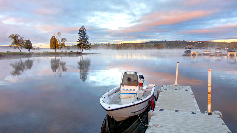 Fog on Rangeley Lake with a small boat tied to a dock in the foreground