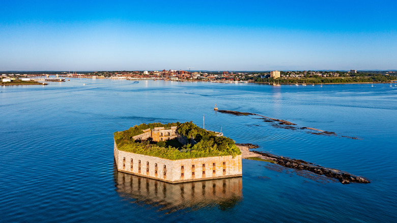 The overgrown stone structure of Fort Gorges on an island in the harbor at Portland, Maine