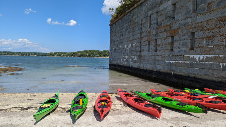 Kayaks along the shore on the beach at Fort Gorges in Portland, Maine