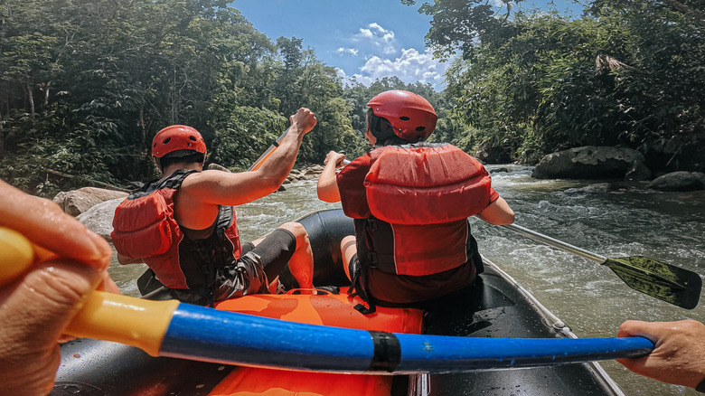 Whitewater rafters paddling on river