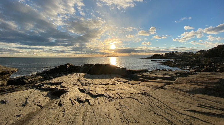 A view of Two Lights State Park with the sun rising over the ocean and rocky coastline