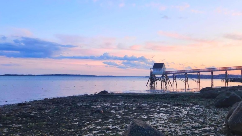 The Falmouth, Maine, beach with a raised dock at sunset