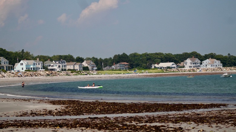 A wide view of Goose Rocks Beach, its cottages, and people enjoying the water