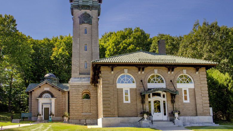 blue sky over green trees and brick historic building