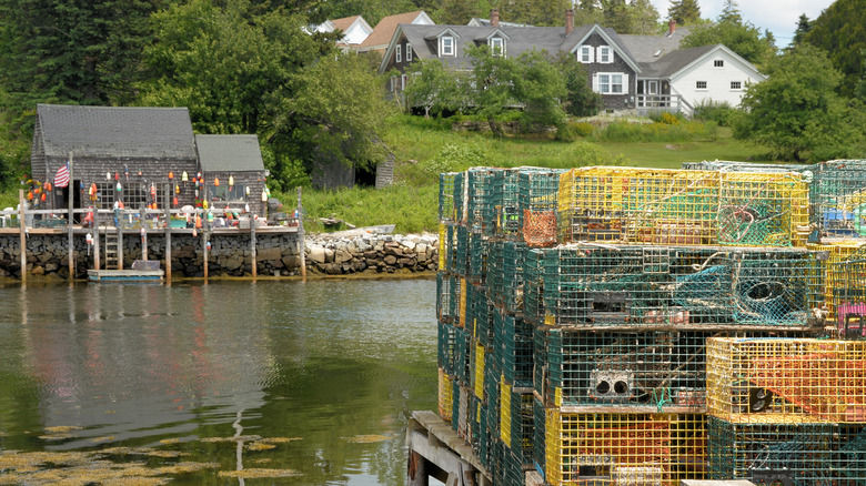 A view of Port Clyde with stacks of lobster traps in the foreground