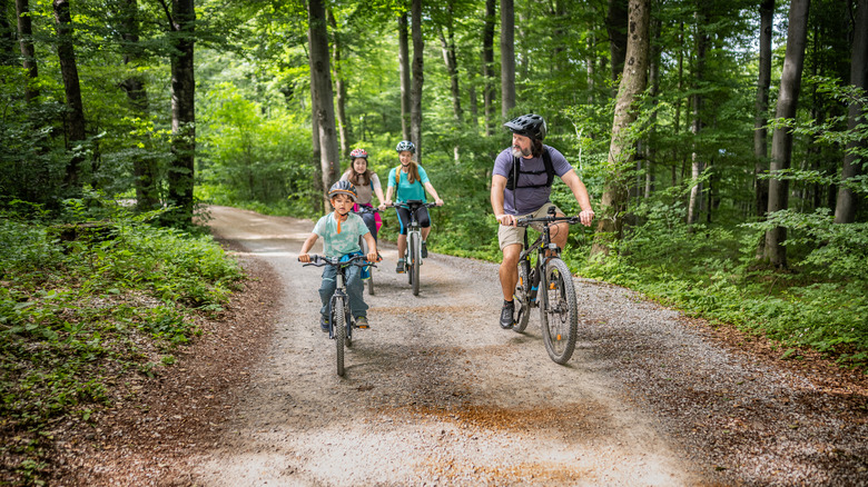 Family biking on forested dirt road