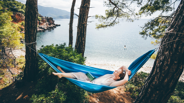 Woman relaxing in hammock at coastal campground with ocean views