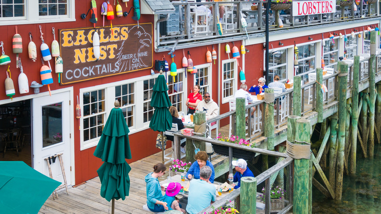Tourists enjoying lobster at a lobster restaurant in Maine on a dock