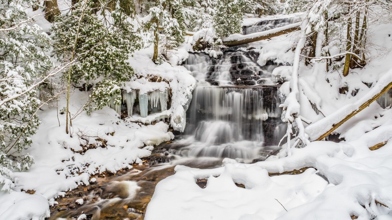 A waterfall cascades down rocks in the winter