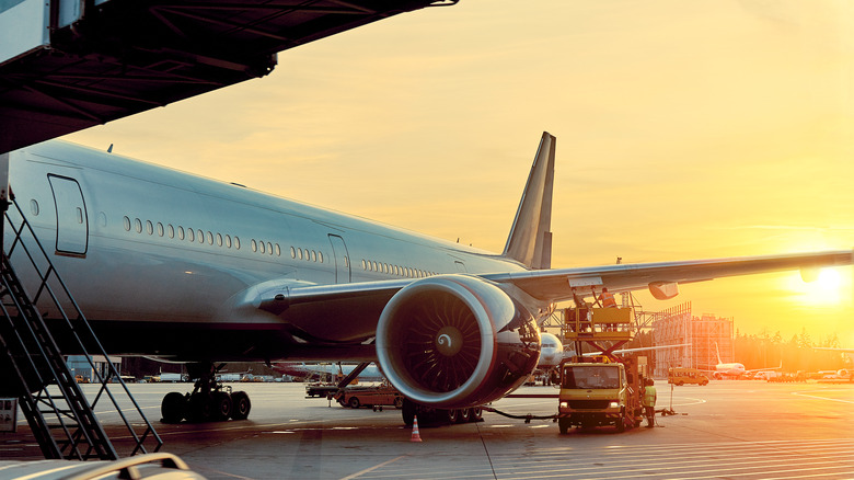 An airplane docked in the terminal at sunrise