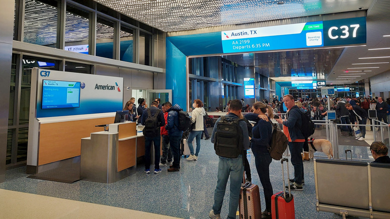 Passengers wait to board American Airlines flight at Dallas Fort Worth