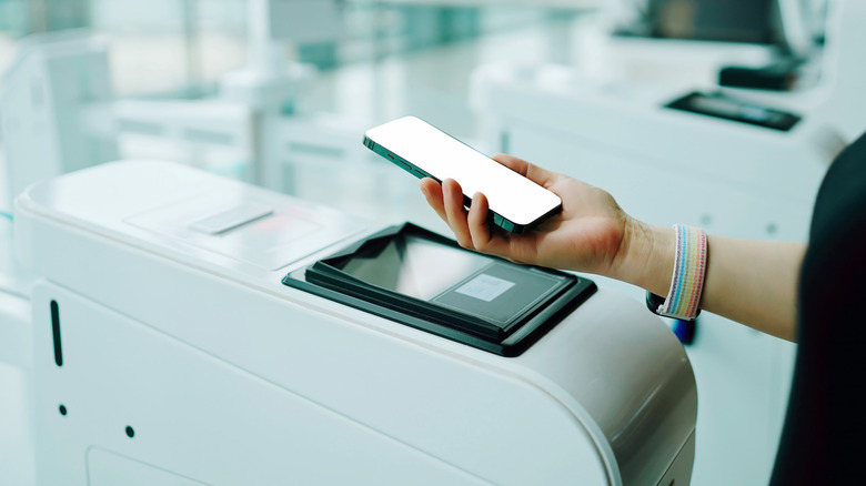 Passenger scans her boarding pass at electronic boarding gate