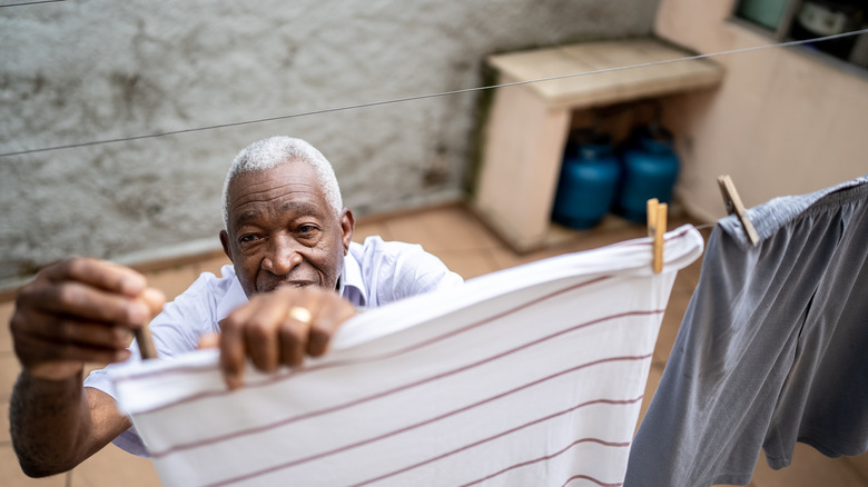 Man hanging up clothes on clothesline