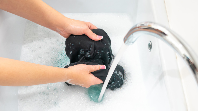 Woman washing clothes in sink