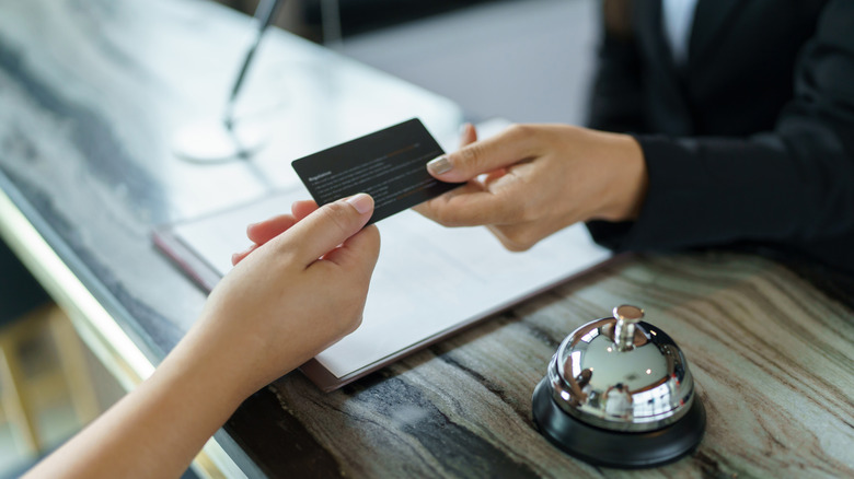 Hotel staff handing over credit card to guest