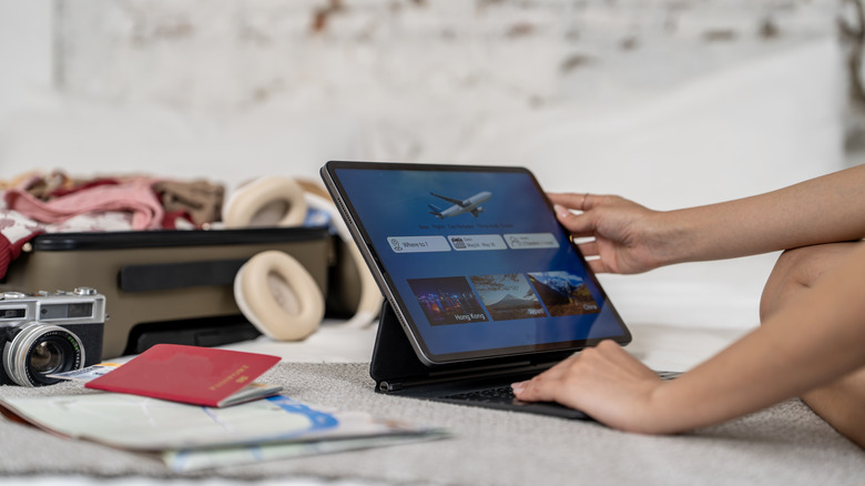 A person booking a flight on a tablet computer