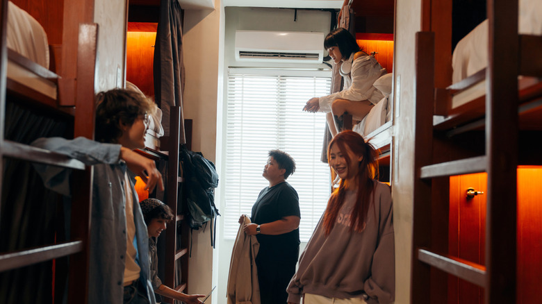 Young travelers hanging out in a hostel dorm room