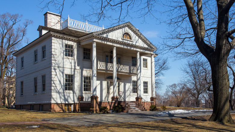 Exterior of the Morris-Jumel Mansion with bare trees in New York City