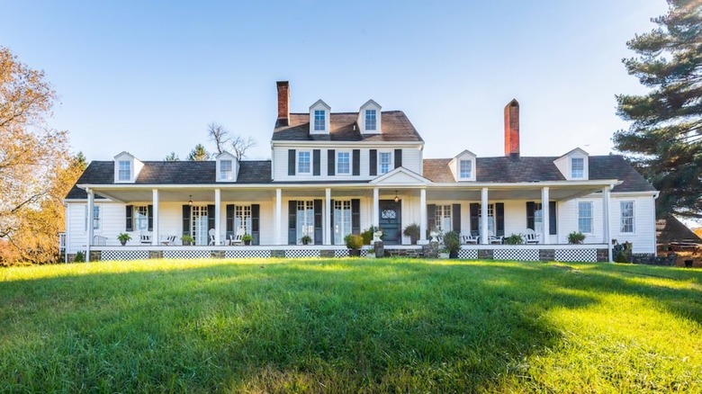 White and gray wooden house with red chimney green lawn