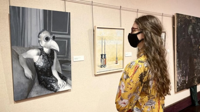 A person admiring artwork on the wall at the Washington County Museum of Fine Art