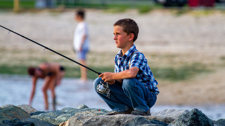 Young boy fishing from a rock pier in Rock Hall, MD