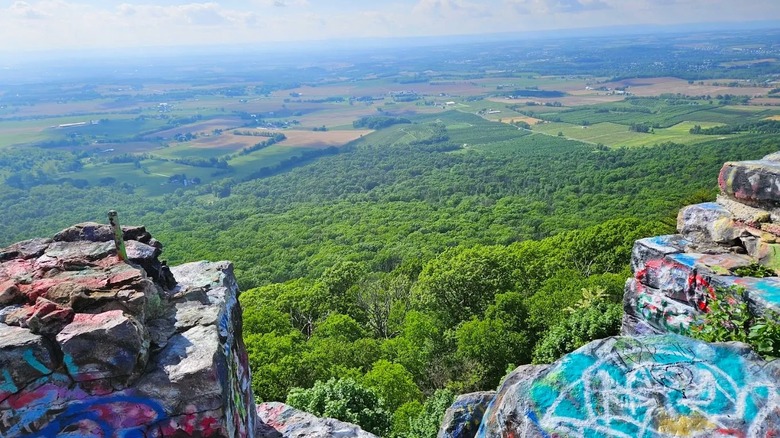 Views of the lush green countryside from a graffiti-covered overlook in Maryland.